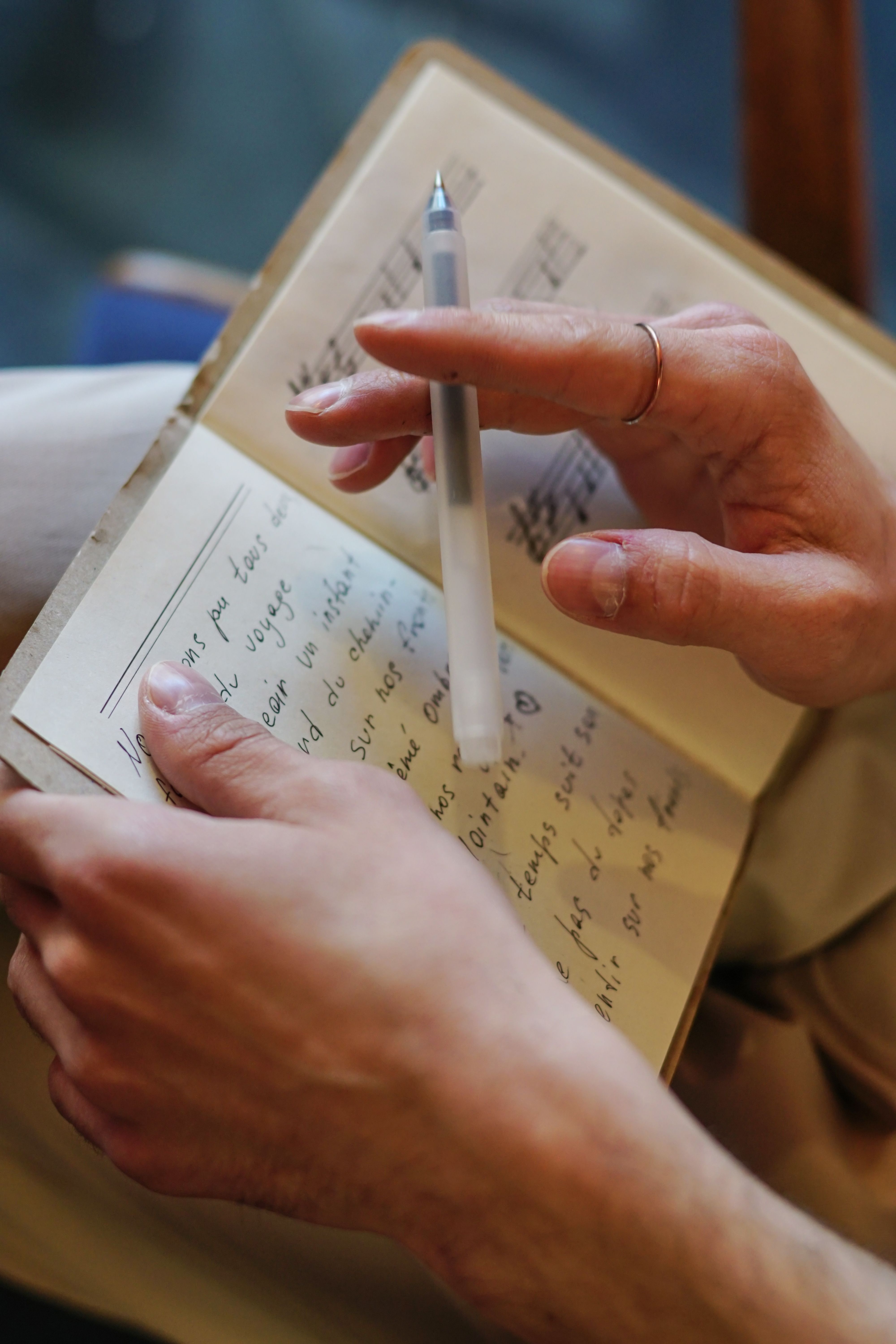 Une main tient un stylo et un carnet