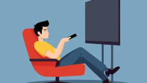 Un homme dans un fauteuil regarde la télé