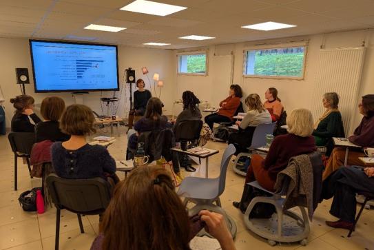 Un groupe d'adultes est installé dans une salle de formation